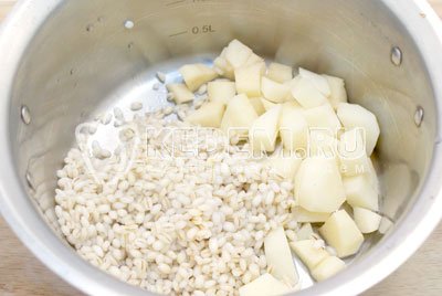 Картофель очистить и нарезать кубиками. Сложить в кастрюлю картофель и полу готовую перловку. Залить водой и поставить вариться