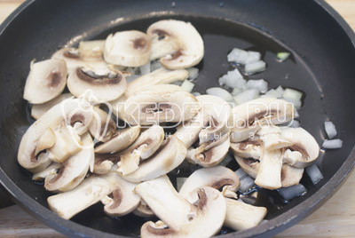 На растительном масле обжарить мелко нашинкованный лук и ломтиками нарезанные грибы 2-3 минуты. Снять и остудить