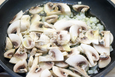 Нарезать грибы ломтиками, лук мелко нашинковать. Обжарить на растительном масле 2-3 минуты