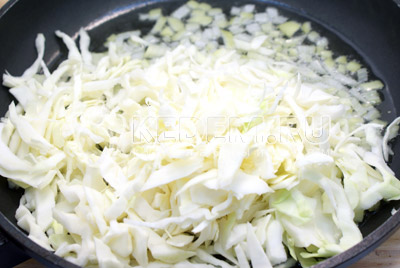 Разогреть растительное масло на сковороде. Добавить лук и капусту, обжаривать 2-3 минуты