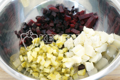 Картошку и свеклу заранее отварить, очистить и остудить. В миску нарезать кубиками свеклу, картофель и соленый огурец