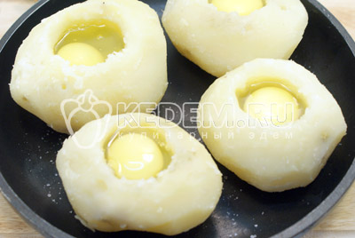 Внутрь посолить и разбить в каждую картофелину по одному яйцу