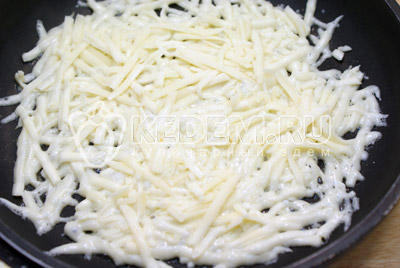 Выложить тертый сыр на раскаленную сковороду, когда сыр начнет таять, поддеть лопаткой и снять со сковороды сырный блин