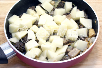 Добавить кубиками нарезанный картофель. И жарить до готовности картофеля