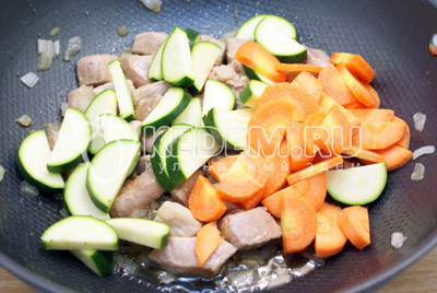 Добавить ломтиками нарезанные кабачок и морковь. Перемешать и готовить 2-3 минуты