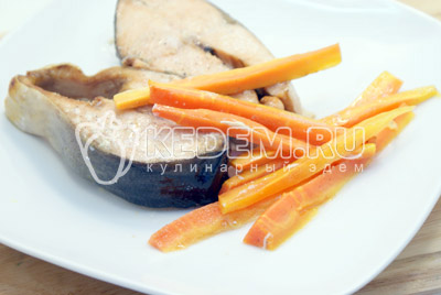 На блюдо выложить стейки рыбы и морковь