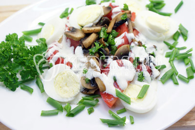 Выложить грибы с помидорами на блюдо. Добавить заправку и уложить сверху кружочки яиц. Посыпать мелко нашинкованным луком