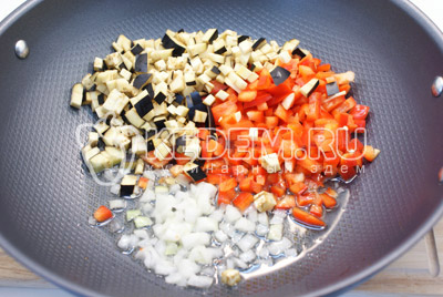 В глубокой сковороде разогреть масло. Добавить кубиками нарезанные овощи и мелко нашинкованный лук. 