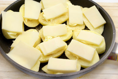 Поверх масла выложить дольками сыр. 