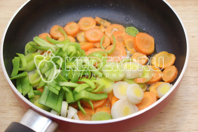  Картофель нарезать кубиками и добавить в бульон, лук убрать из бульона. Морковь нарезать колечками, лук порей мелко нарезать.Обжарить порей и морковь на растительном масле. 