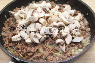 Добавить кубиками нарезанные грибы и готовить на среднем огне 3-5 минут.Посолить и поперчить по вкусу. Выложить начинку на блюдо и остудить. 