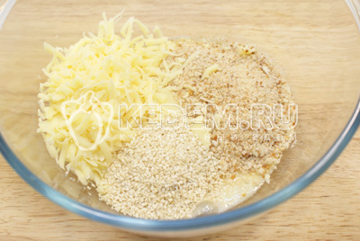 Для кляра взбить в миске яйца, добавить тертый сыр, панировочные сухари, кунжут. 