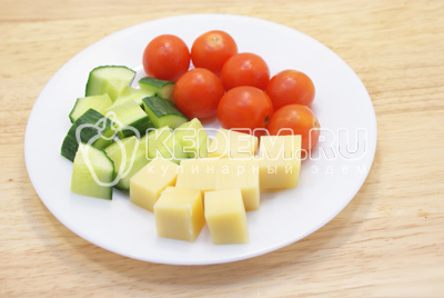 Сыр и огурец нарезать кубиками, помидорчики разрезать на половинки