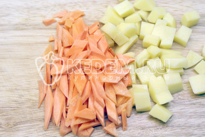 Картофель порезать кубиками, морковь ромбиками. 