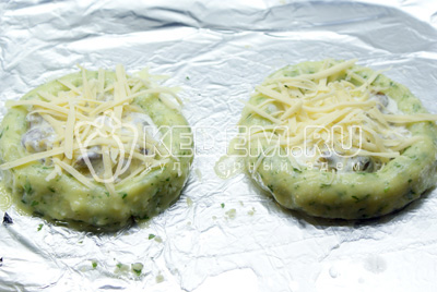 Из картофеля скатать 2 колбаски и замкнув их в кольцо, обмазать каждую желтком и выложить внутрь по очереди грибы, сметану, сверху посыпать тёртым сыром