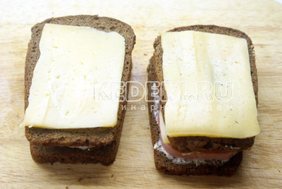 Закрыть вторым куском смазанного майонезом хлеба, на который положить сыр