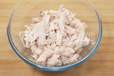 Куриное филе заранее поставить варить до готовности. Остудить в бульоне. Нарезать филе небольшой соломкой или разделить на волокна. Сложить в миску