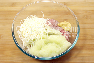 В миску с фаршем добавить измельченный лук, горчицу и половину тертого сыра