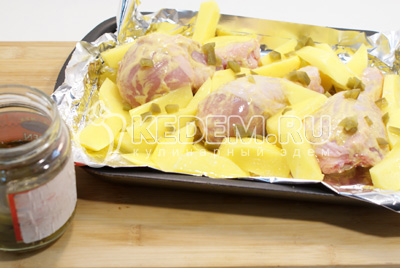 Добавить картофель на противень с курицей. Сверху добавить нарезанные кусочками острые перчики халапеньо