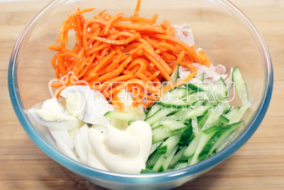 Добавить соломкой нарезанный свежий огурец, морковь по-корейски и майонез