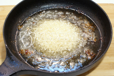 На сковороде с оставшимся от курицы маслом обжарить рис и добавить воды. Посолить по вкусу. 