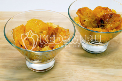 Выложить ломтики апельсинов в креманки