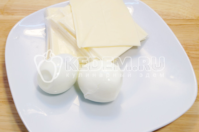 Снять с сырных пластинок упаковку, яйца отварить до готовности и очистить