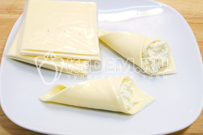 Каждый пласт сыра свернуть кулечком и начинить начинкой