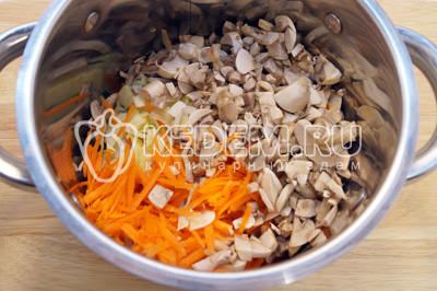 Сложить в кастрюлю измельченную капусту, грибы и тертую морковь. Добавить 100 мл воды и тушить на среднем огне 3-5 минут