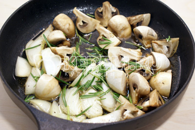 Вынуть рульку из сковороды и добавить грибы, лук и розмарин. Посолить и обжарить 1-2 минуты
