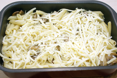 Переложить макароны с грибами в форму. Посыпать тертым сыром