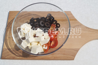 В миску сложить четвертинками нарезанные помидоры, маслины колечками и сыр кубиками