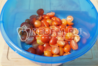 Нарезать помидоры на половинки и сложить в миску