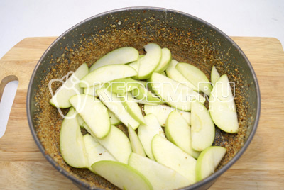 Форму смазать сливочным маслом и посыпать сухарями. Выложить слой яблок на дно формы.