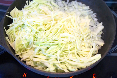 В сковороде с растительным маслом обжарить лук и капусту 5-7 минут, помешивая. 