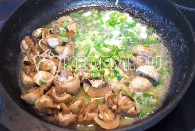 Обжарить на сковороде с растительным маслом грибы и мелко нарубленный зеленый лук, 2-3 минуты. Посолить.
