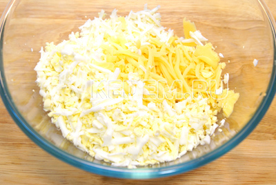 В миске смешать тертый сыр и тертые отварные яйца.