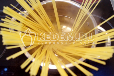 Опустить спагетти в кипящую подсоленную воду и варить до готовности.