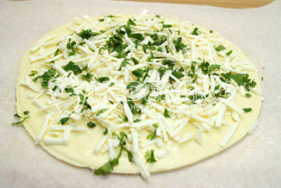 Выложить на круг теста зелень и сыр.