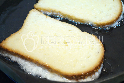 Окунуть ломтик хлеба во взбитые яйца и выложить на горячую сковороду с растительный маслом.