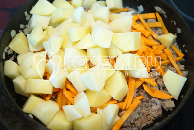 Нарезать кубиками картофель, морковь нарезать соломкой. Добавить овощи в сковороду.