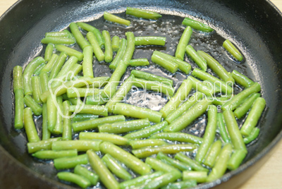 На сковороде с растительным маслом обжарить стручковую фасоль, добавить немного воды и тушить 3-4 минуты до мягкости.