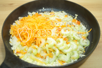 Добавить ломтиками нарезанный сельдерей и тертую морковь. Обжаривать 1-2 минуты.