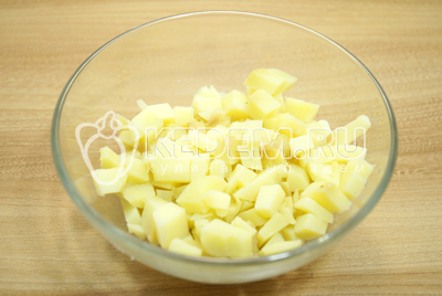 Остывший картофель очистить и нарезать кубками в миску.