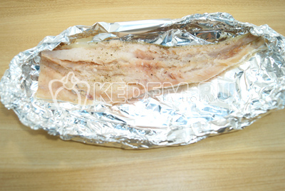 Выложить рыбную половинку на форму из фольги (просто сверните фольгу в два слоя и сожмите края, делая форму тарелки по размеру рыбы).