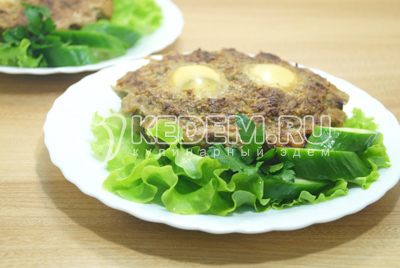 Выложить на тарелки с листьями салата и зеленью.