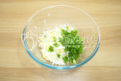 В миску натереть яйца и мелко нарезать зеленый лук.