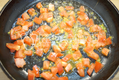 На сковороде разогреть растительное масло и обжарить кубиками нарезанные помидоры.