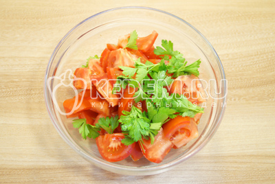 В миску сложить нарезанные помидоры и небольшие листики петрушки (без стеблей).