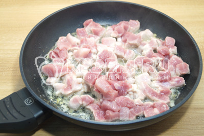 Нарезать мелко лук и кусочками мясо, обжарить на сковороде с растительным маслом 2-3 минуты.